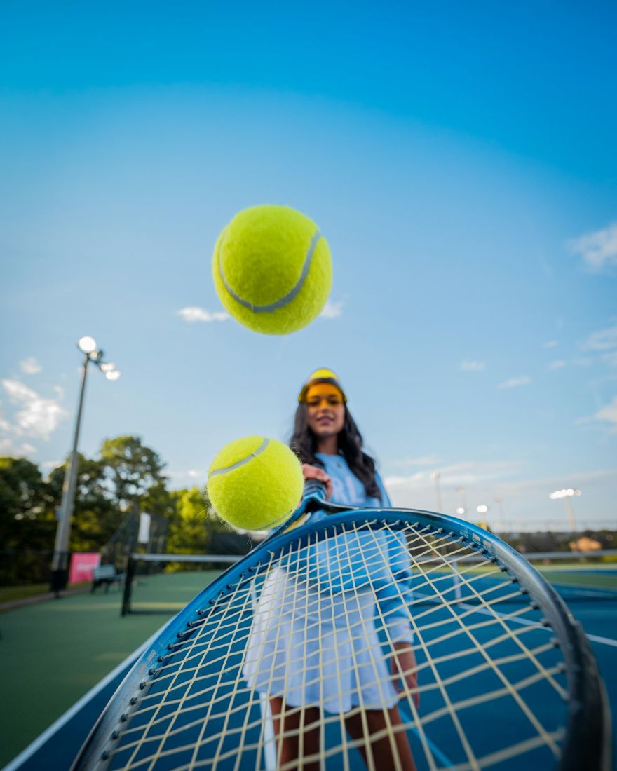 A tennis player holding a racket and two balls